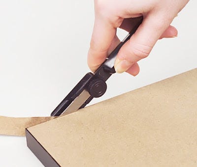 A dust cover trimmer in use on a wood frame A dust cover trimmer in use on a wood frame