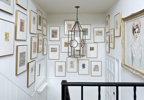 A varied selection of gold frames on a gallery wall A varied selection of gold frames on a gallery wall