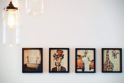 Minimalistic and quirky gallery wall with all artwork in a 1 x 4 grid Minimalistic and quirky gallery wall with all artwork in a 1 x 4 grid