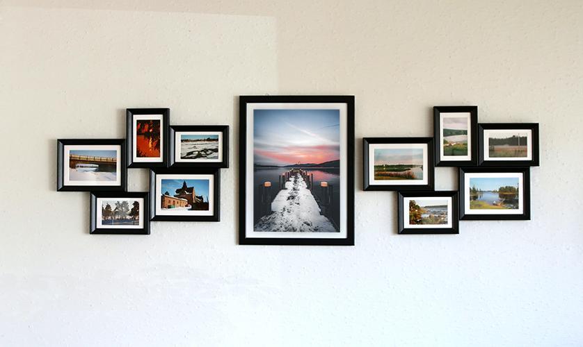 Gallery wall of vacation photos in black wooden picture frame
