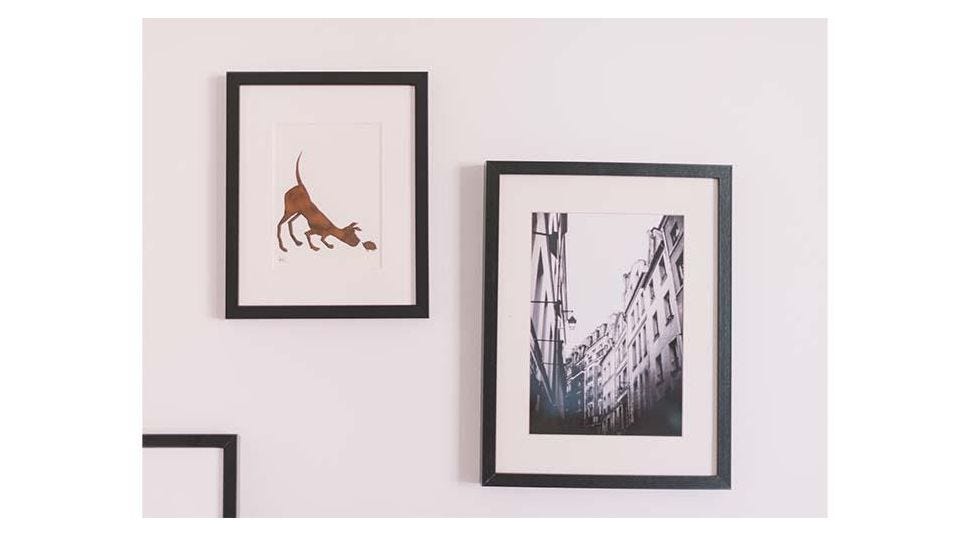 Gallery wall of photos framed with custom wood picture frames and mat boards