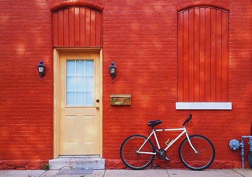 A photo of an orange door in a red wall A photo of an orange door in a red wall
