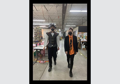 Employees in Halloween costume walking through American Frame's production facility. Employees in Halloween costume walking through American Frame's production facility.
