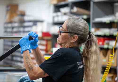 A team member fills the corners of wooden picture frames. A team member fills the corners of wooden picture frames.