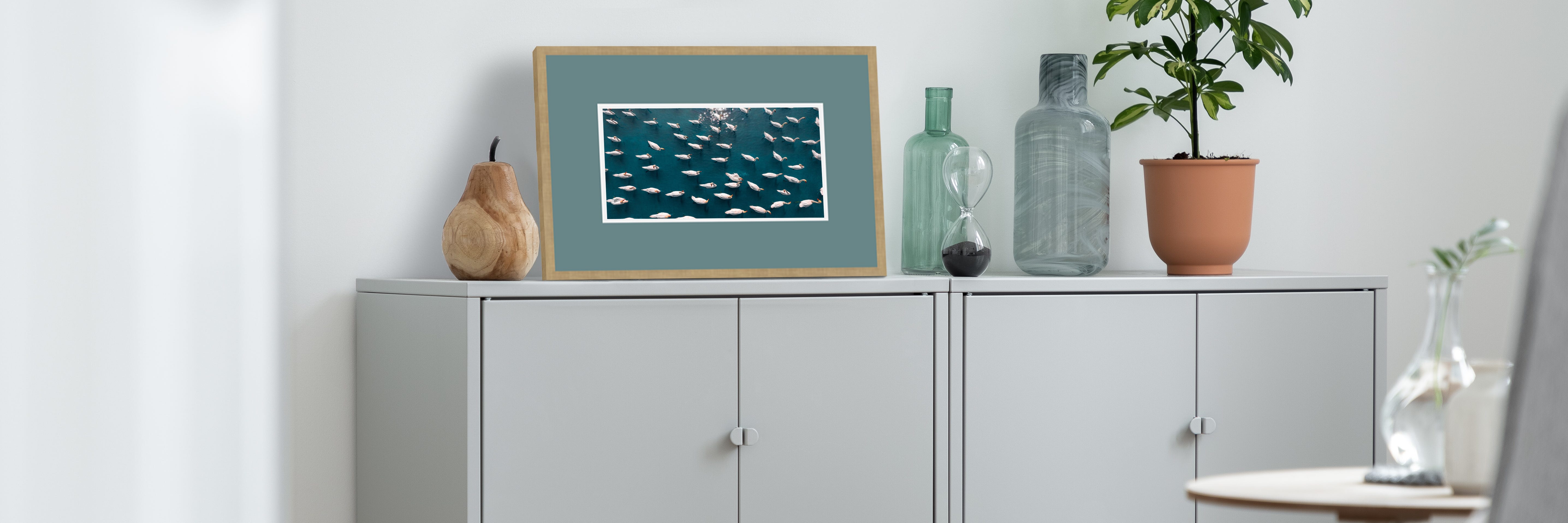 A framed picture of swans in a serene setting.