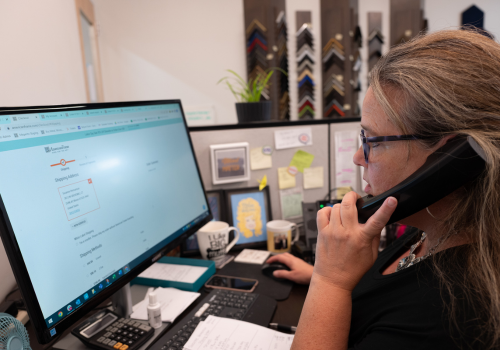 US based female customer service worker is on the phone assisting a customer US based female customer service worker is on the phone assisting a customer