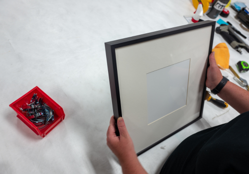 Metal picture frame with white mat board being assembled