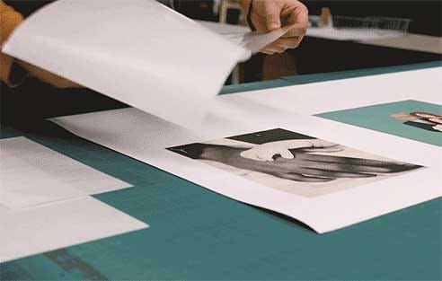 Laminate sheet being hand applied to a black and white photograph printed on canvas